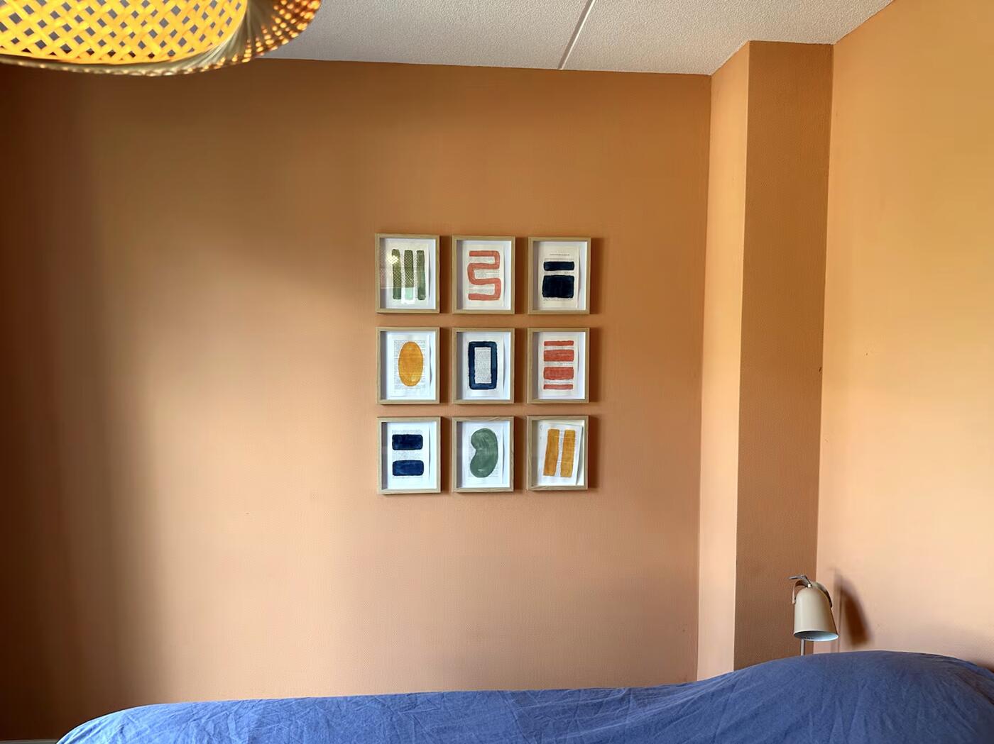 Slaapkamer beneden met terracotta muur en schilderijen