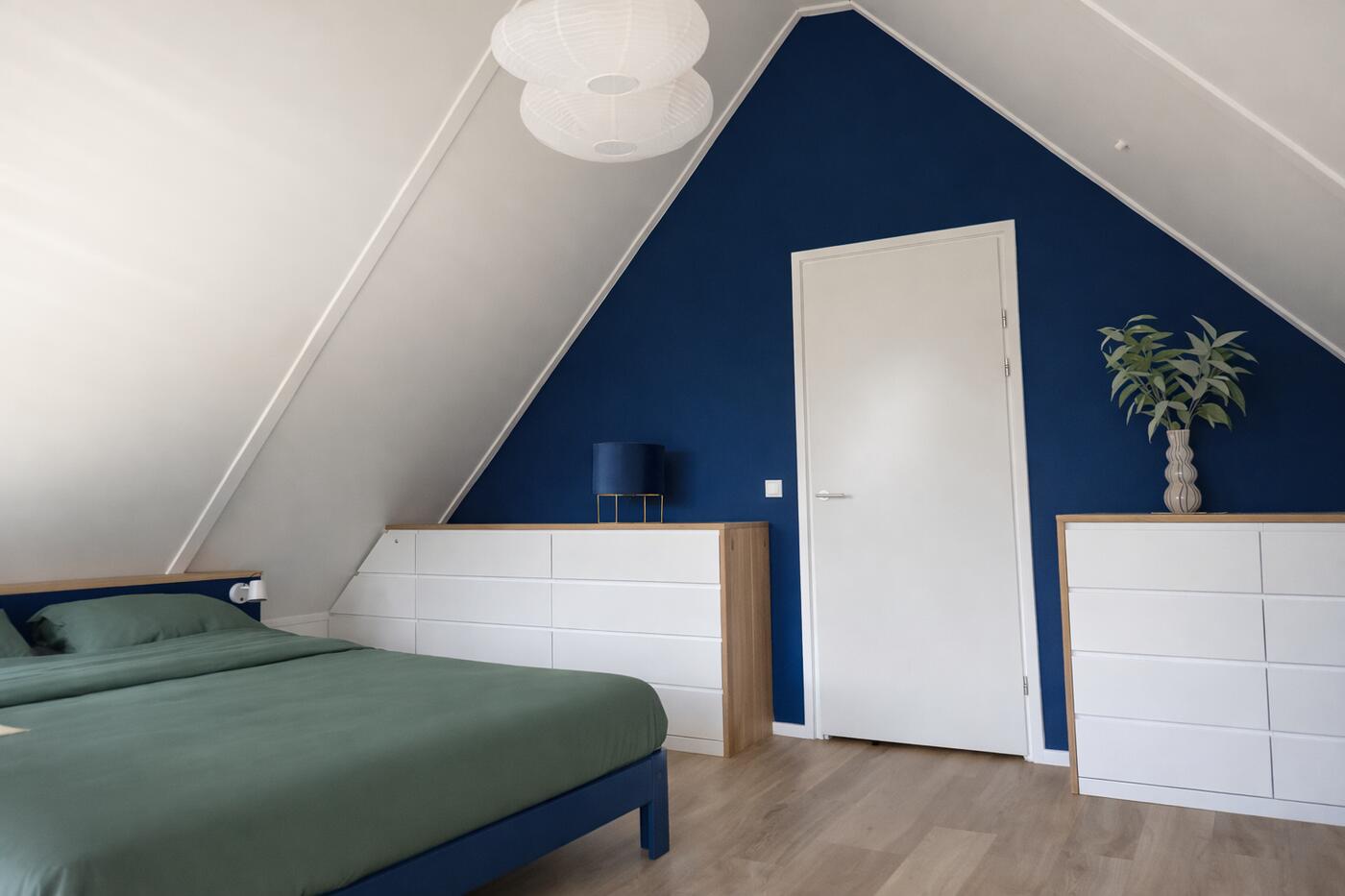 Overzicht van de masterbedroom met ladekasten