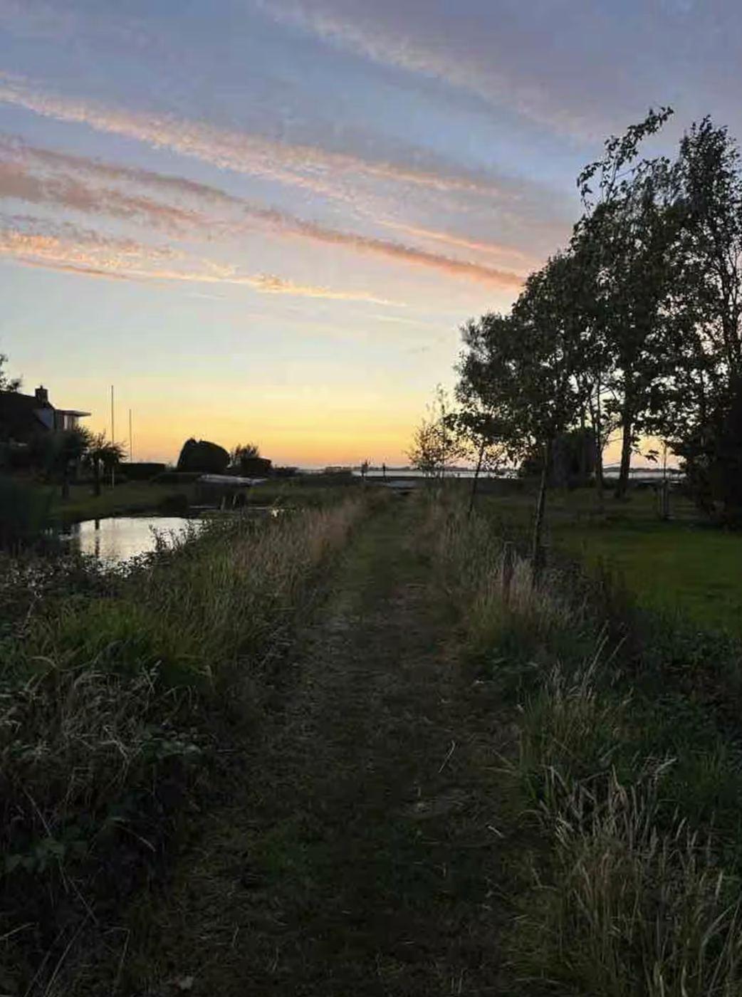Graspad langs de vaart naar het meer bij zonsondergang
